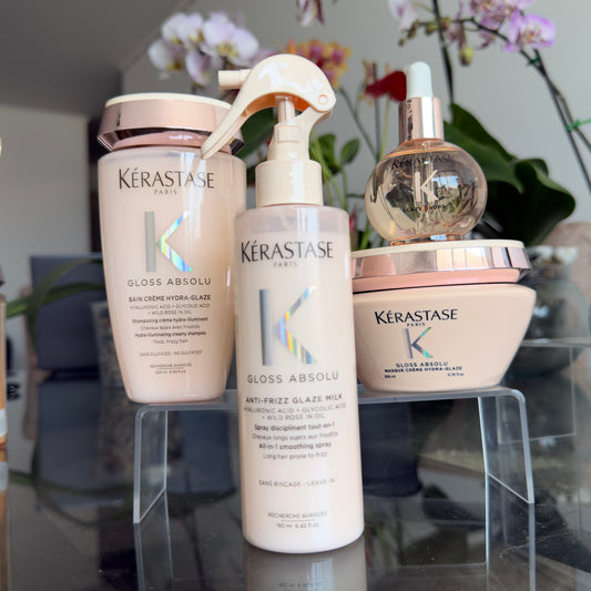 Foto real del kit Kérastase Gloss Absolu con shampoo cremoso, mascarilla, spray Glaze Milk y aceite Glaze Drops.