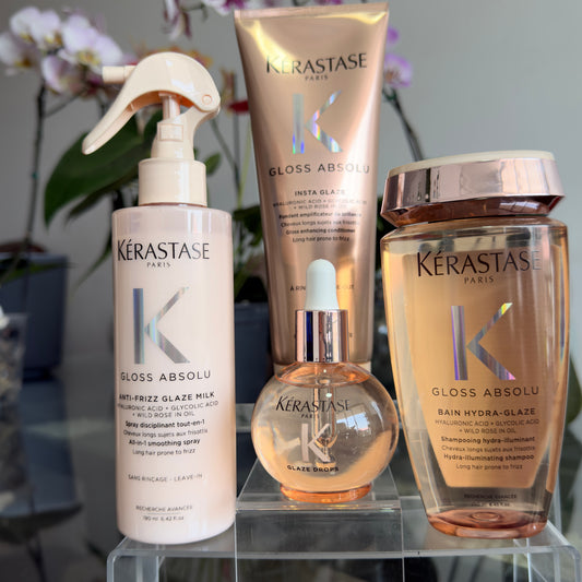 Foto real del kit Kérastase Gloss Absolu con shampoo Hydra-Glaze, acondicionador Insta Glaze, spray y aceite sobre bases transparentes.