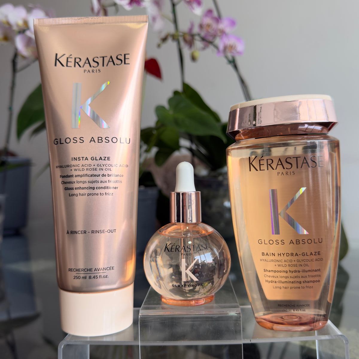 Foto real del pack Kérastase Gloss Absolu con acondicionador Insta Glaze, aceite Glaze Drops y shampoo Hydra-Glaze.