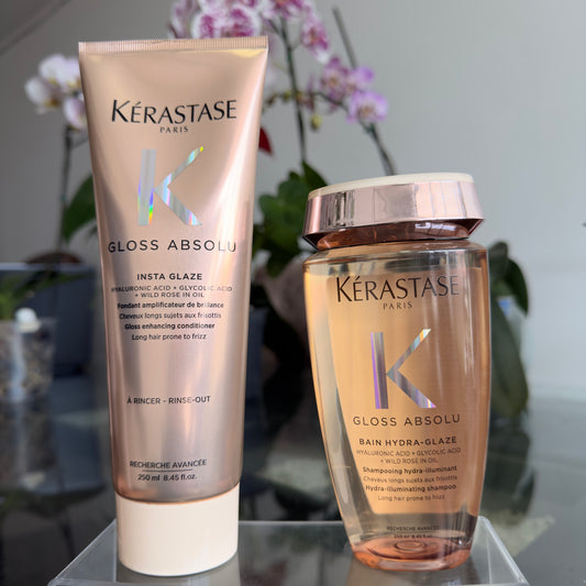 Foto real del dúo Kérastase Gloss Absolu con acondicionador Insta Glaze y shampoo Bain Hydra-Glaze sobre una base transparente.